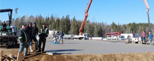 Stacie Hook, Bryan Snider, Steve Blackwell and Ben Mieske at one corner of the 15,000 square foot concrete pad which will serve as the floor for the new materials storage facility at Hook’s Castle Building Centre just south of Cloyne. Photo/Craig Bakay